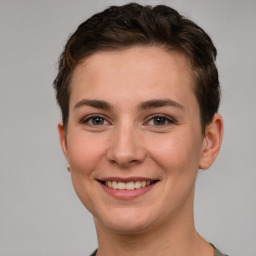 Joyful white young-adult female with short  brown hair and grey eyes