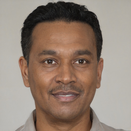 Joyful latino adult male with short  black hair and brown eyes