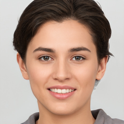 Joyful white young-adult female with short  brown hair and brown eyes