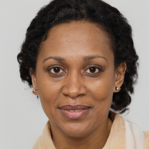 Joyful black adult female with medium  brown hair and brown eyes