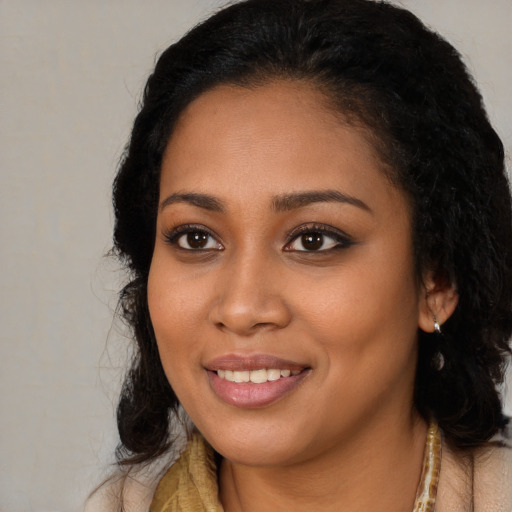 Joyful black young-adult female with long  black hair and brown eyes