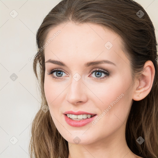 Joyful white young-adult female with long  brown hair and blue eyes