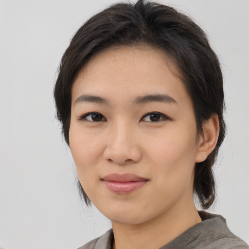 Joyful asian young-adult female with medium  brown hair and brown eyes