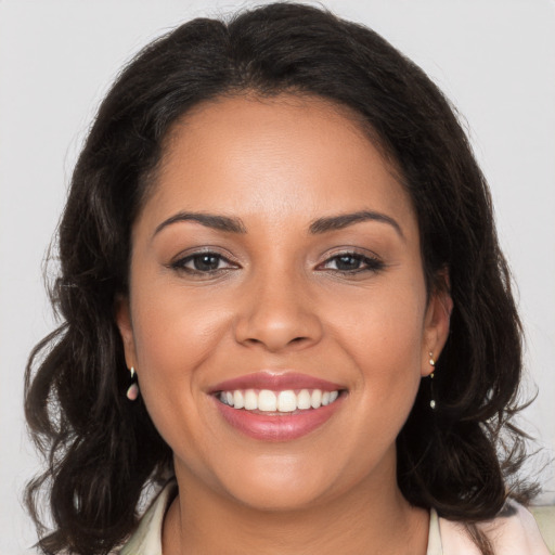 Joyful latino young-adult female with long  brown hair and brown eyes