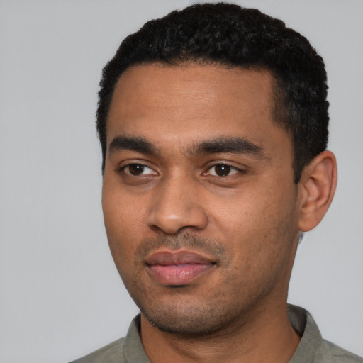 Joyful black young-adult male with short  black hair and brown eyes