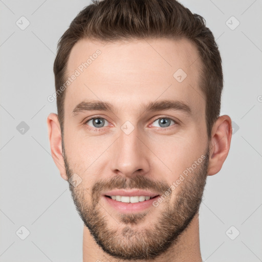 Joyful white young-adult male with short  brown hair and grey eyes