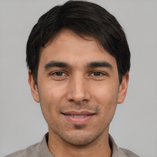 Joyful white young-adult male with short  black hair and brown eyes