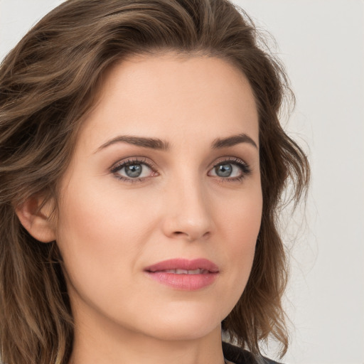 Joyful white young-adult female with long  brown hair and blue eyes