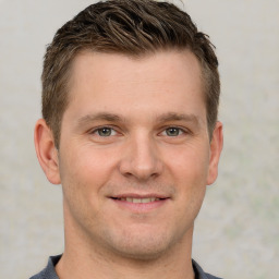 Joyful white young-adult male with short  brown hair and grey eyes