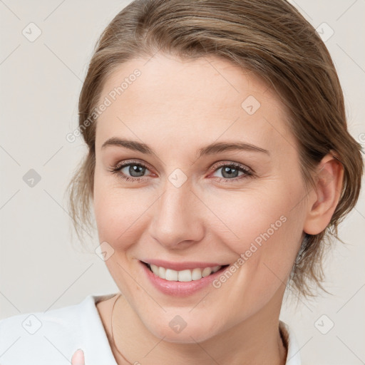 Joyful white young-adult female with medium  brown hair and blue eyes