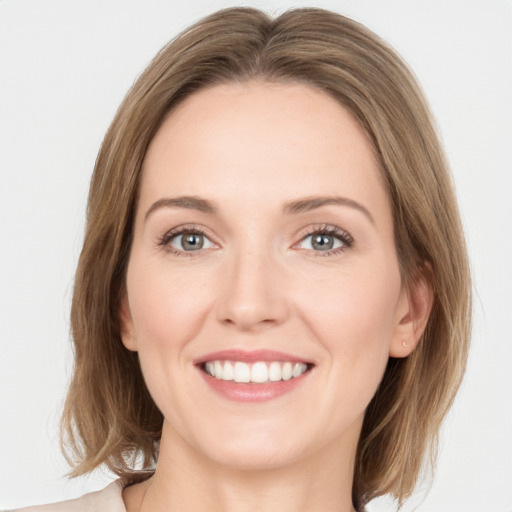 Joyful white young-adult female with medium  brown hair and green eyes