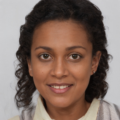 Joyful black young-adult female with medium  brown hair and brown eyes