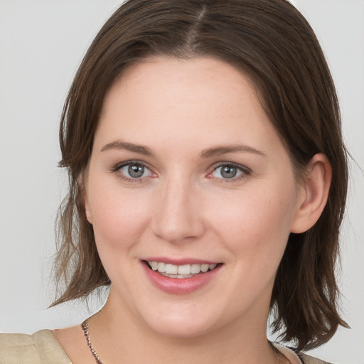 Joyful white young-adult female with medium  brown hair and grey eyes