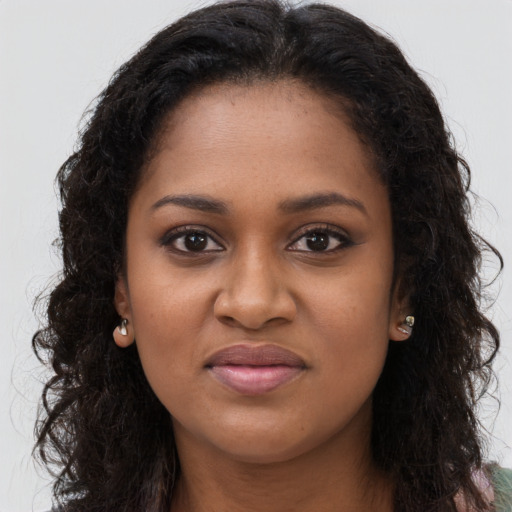 Joyful black young-adult female with long  brown hair and brown eyes