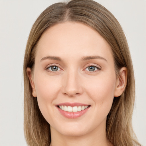 Joyful white young-adult female with long  brown hair and grey eyes