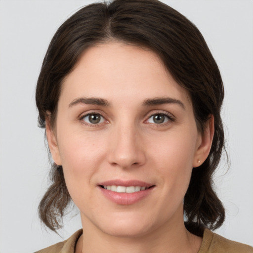 Joyful white young-adult female with medium  brown hair and grey eyes