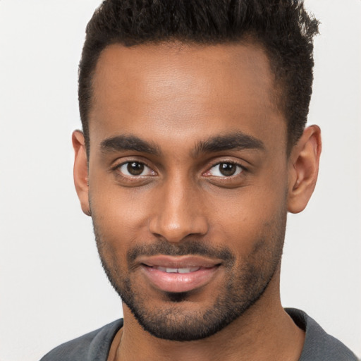 Joyful black young-adult male with short  brown hair and brown eyes