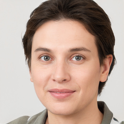 Joyful white young-adult female with medium  brown hair and grey eyes