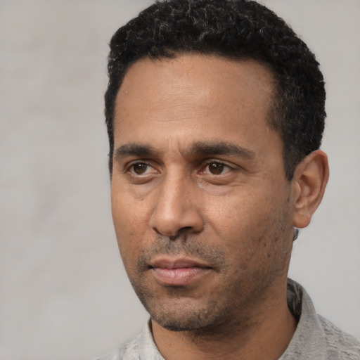 Neutral latino adult male with short  black hair and brown eyes