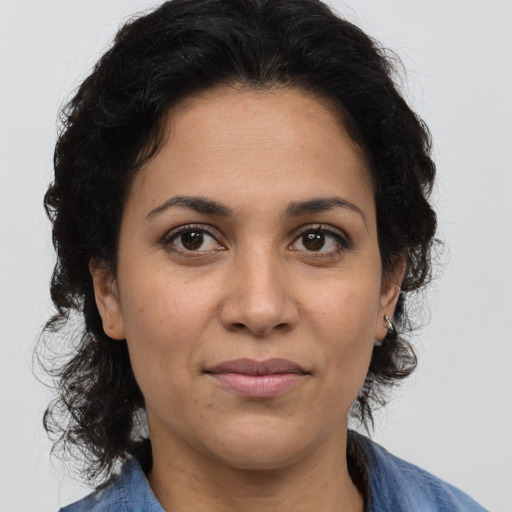 Joyful latino adult female with medium  brown hair and brown eyes