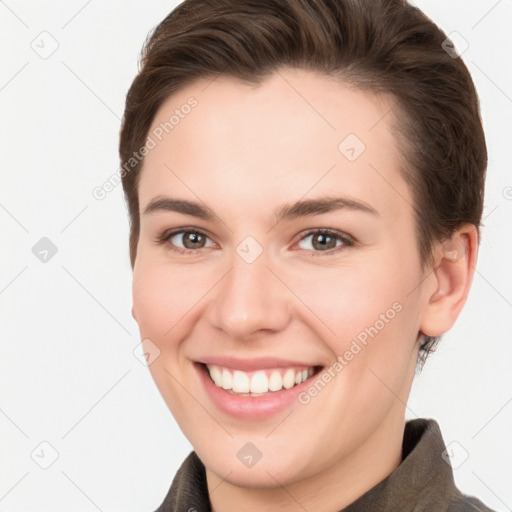 Joyful white young-adult female with short  brown hair and grey eyes