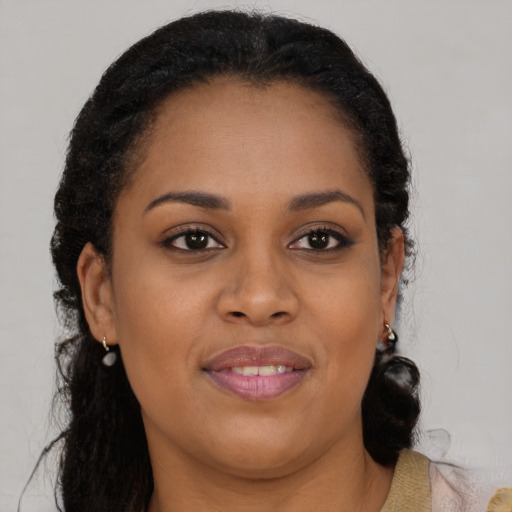 Joyful black young-adult female with long  brown hair and brown eyes