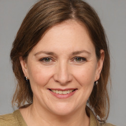 Joyful white adult female with medium  brown hair and grey eyes