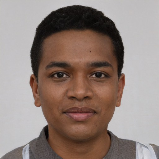 Joyful black young-adult male with short  black hair and brown eyes