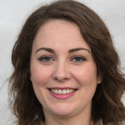 Joyful white adult female with long  brown hair and brown eyes