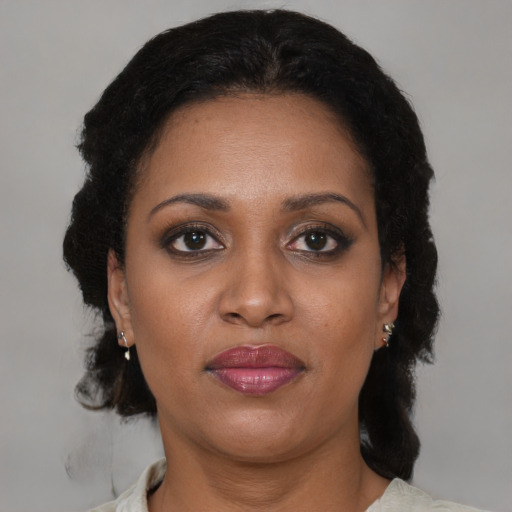 Joyful black adult female with medium  brown hair and brown eyes
