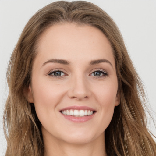 Joyful white young-adult female with long  brown hair and green eyes