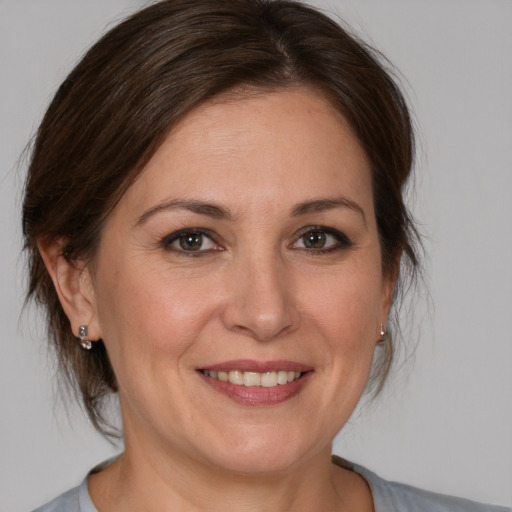 Joyful white adult female with medium  brown hair and brown eyes