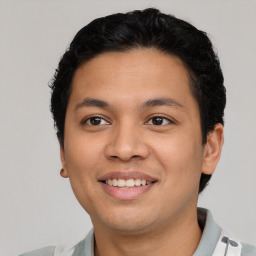 Joyful latino young-adult male with short  brown hair and brown eyes