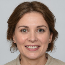 Joyful white adult female with medium  brown hair and grey eyes