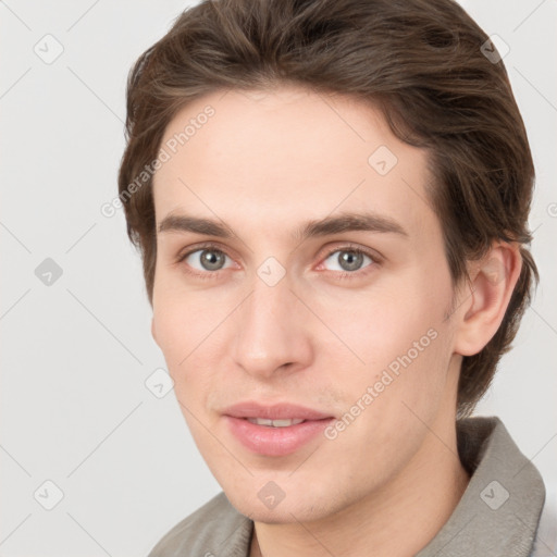 Joyful white young-adult male with short  brown hair and grey eyes