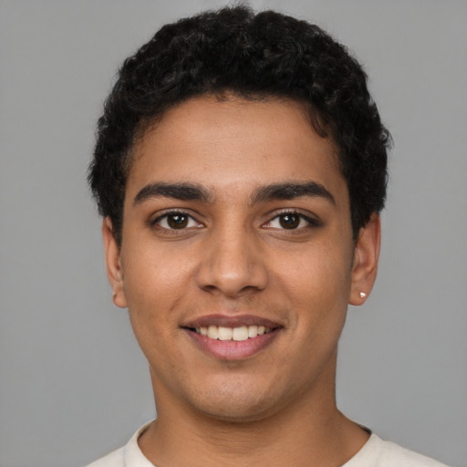 Joyful latino young-adult male with short  brown hair and brown eyes