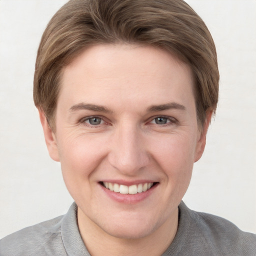 Joyful white young-adult female with short  brown hair and grey eyes