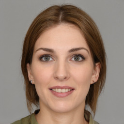 Joyful white young-adult female with medium  brown hair and grey eyes