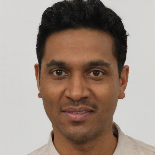Joyful black young-adult male with short  black hair and brown eyes