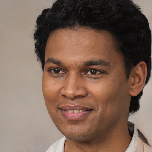 Joyful black young-adult male with short  black hair and brown eyes
