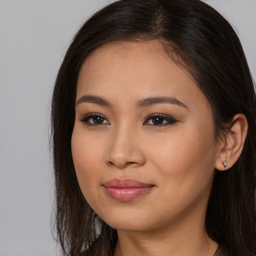 Joyful asian young-adult female with long  brown hair and brown eyes