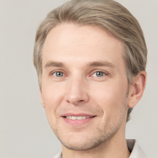 Joyful white adult male with short  brown hair and grey eyes