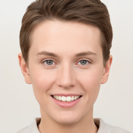 Joyful white young-adult female with short  brown hair and grey eyes