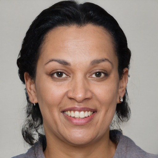 Joyful latino adult female with medium  brown hair and brown eyes
