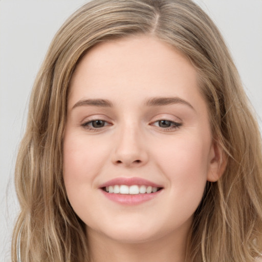 Joyful white young-adult female with long  brown hair and grey eyes