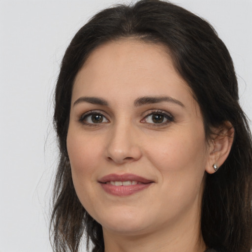 Joyful white young-adult female with long  brown hair and brown eyes