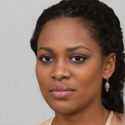 Joyful black young-adult female with long  brown hair and brown eyes