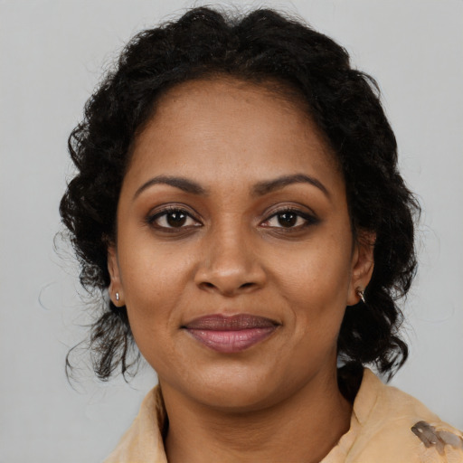 Joyful black young-adult female with long  brown hair and brown eyes