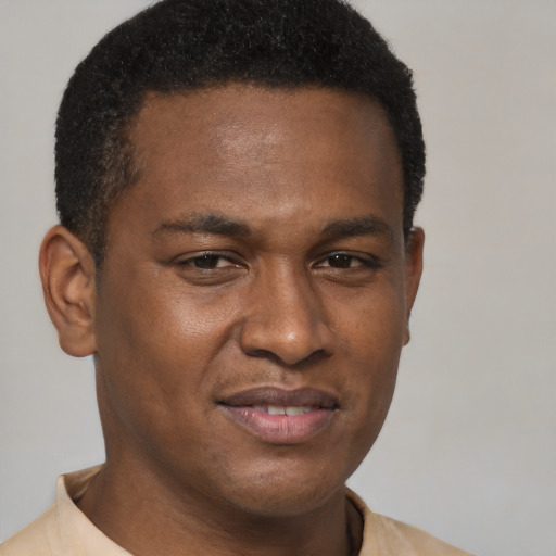 Joyful black young-adult male with short  brown hair and brown eyes