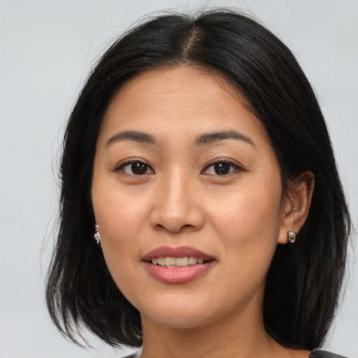 Joyful asian young-adult female with medium  brown hair and brown eyes